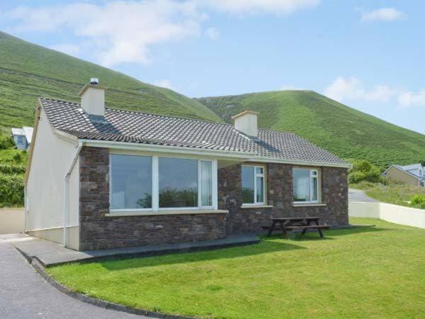 a small house with a hill in the background at St Ann's Rossbeigh in Glenbeigh
