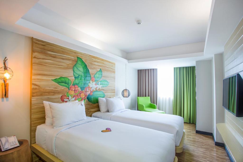 a hotel room with two beds and a tv at MaxOneHotels at Ubud - CHSE Certified in Ubud