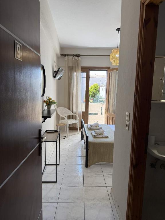 a room with a bed and a bathroom with a sink at Roula's Apartment in Limenaria