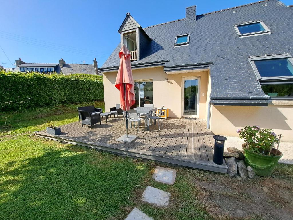 a patio with a table and an umbrella at Chambre d'Hôtes Valérie in Penvénan