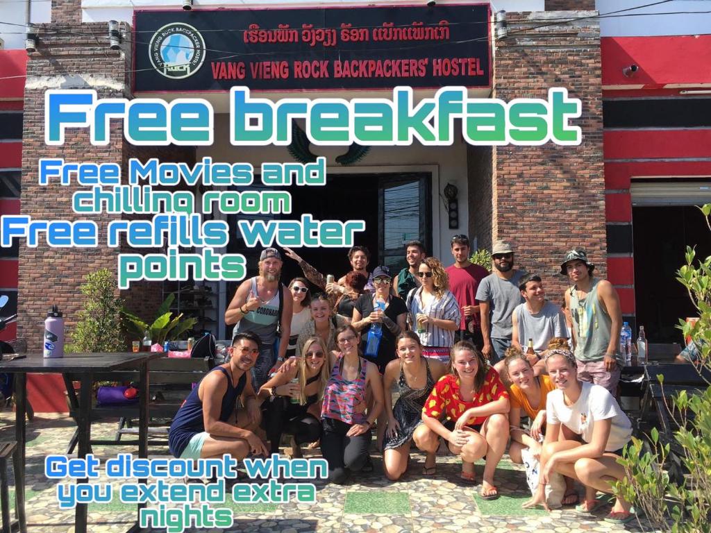 a group of people posing for a picture in front of a building at Vangvieng Rock Backpacker Rooftop Hostel in Vang Vieng
