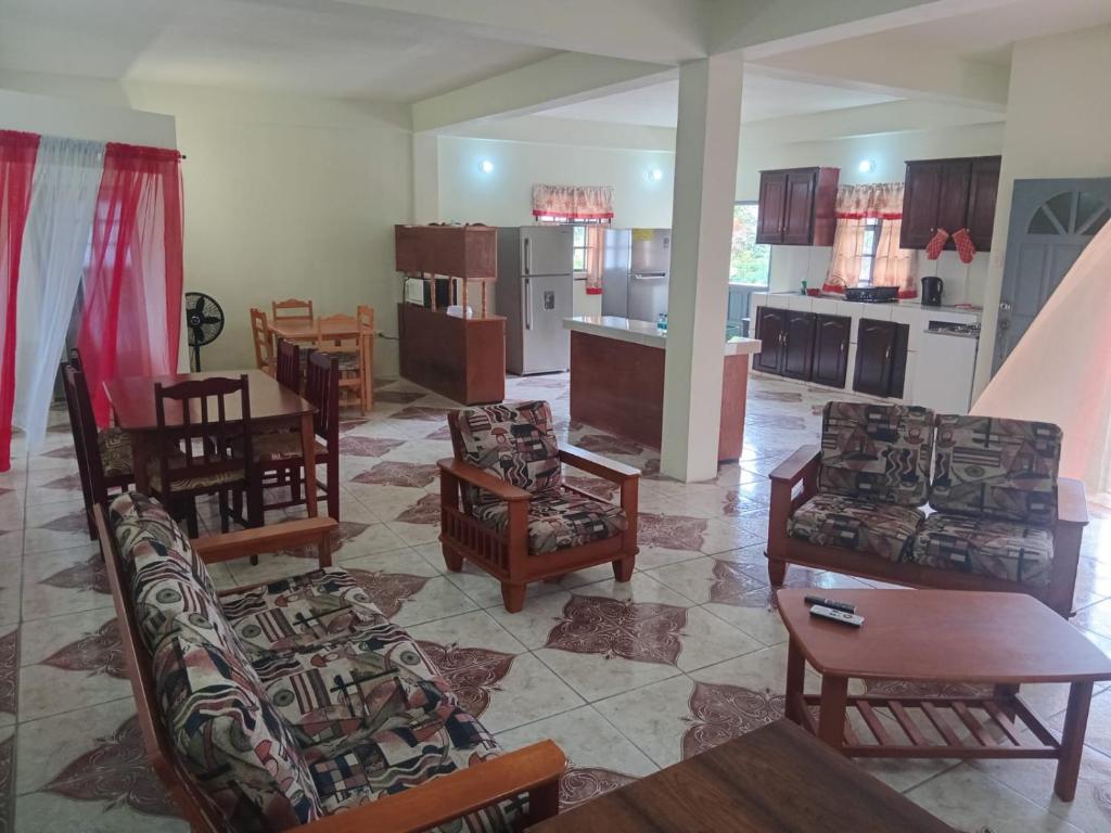 a living room with chairs and tables and a kitchen at Parakeet Hideaway in Mason Hall