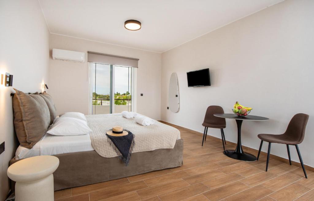 a bedroom with a bed and a table and chairs at Sokrates Studios in Afantou