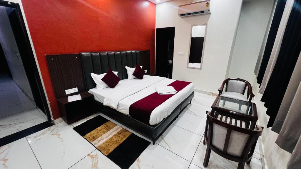 a bedroom with a bed and a chair in it at Hotel AJL in Rohtak