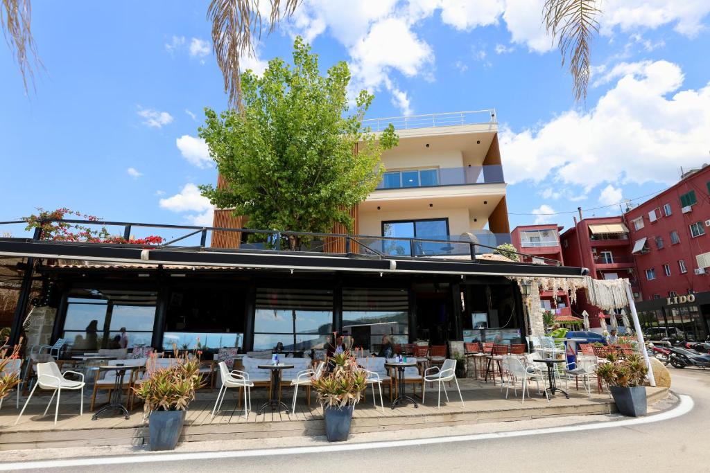 a restaurant with tables and chairs in front of a building at Manolo & Jolie Luxury Villa in Himare