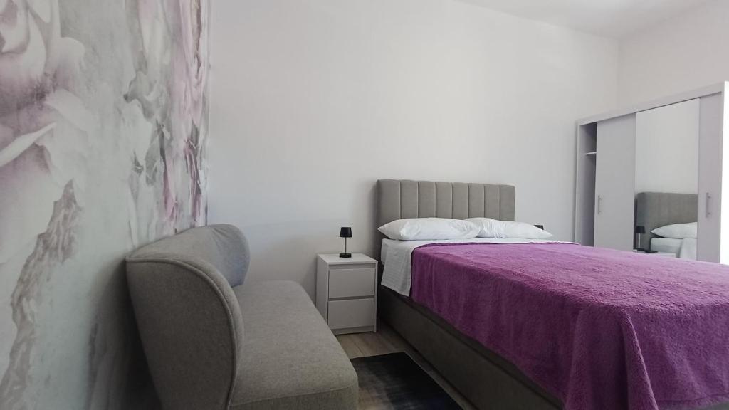 a bedroom with a purple bed and a chair at Apartment house Nena in Krk