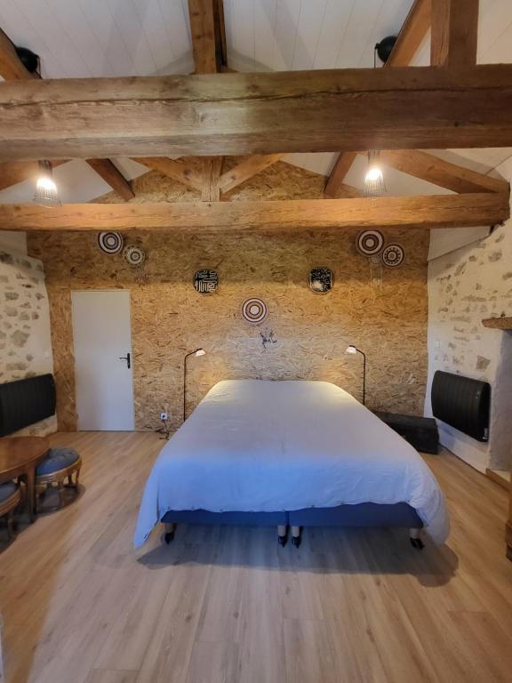 a bedroom with a large bed in a room with wooden floors at Naëlo Chartreuse in Biviers