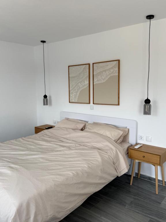 a white bedroom with a large bed with two windows at Saint Nectaire in Kardhianí