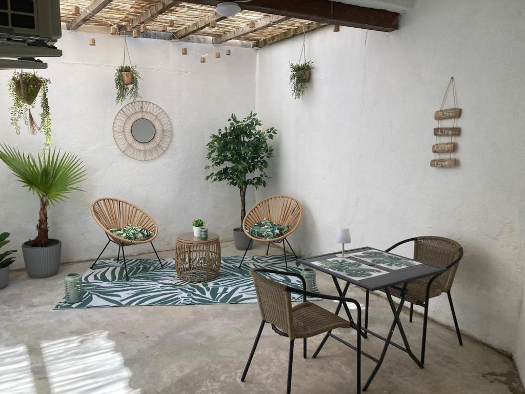 a patio with a table and chairs and plants at Le patio de la place in Saint-André-de-Sangonis