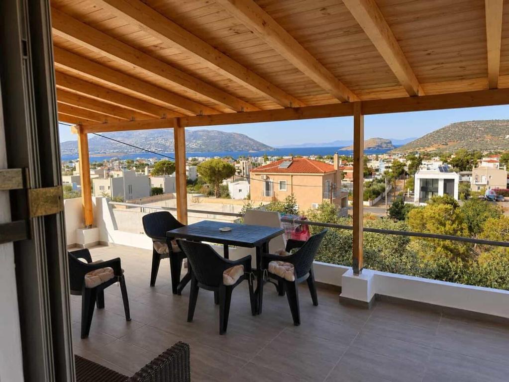 a patio with a table and chairs on a balcony at Panorama in Porto Rafti