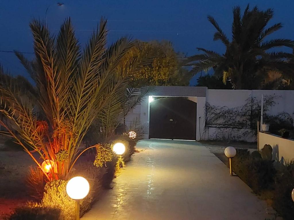 a garage with two lights in front of it at night at Résidence Kyranis appartement Noix de Coco in Sfax