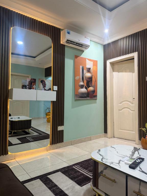a living room with a mirror and a table at Ivory Max in Ikeja