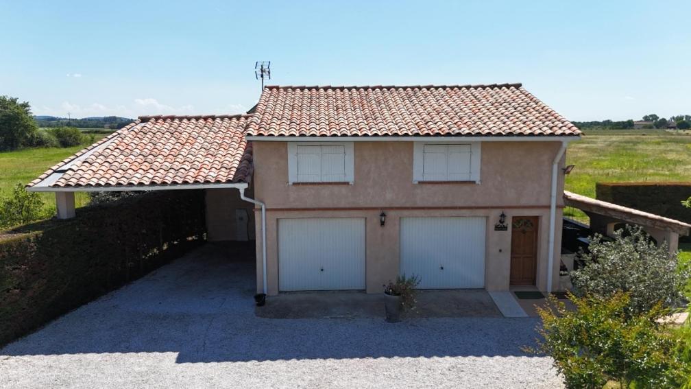 a house with two garage doors and a roof at Gite chez kinou in Montans