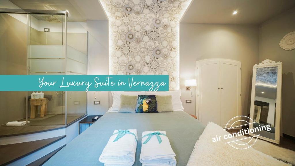 a bedroom with a bed with two towels on it at Vernazza Luxury Apartment in Vernazza