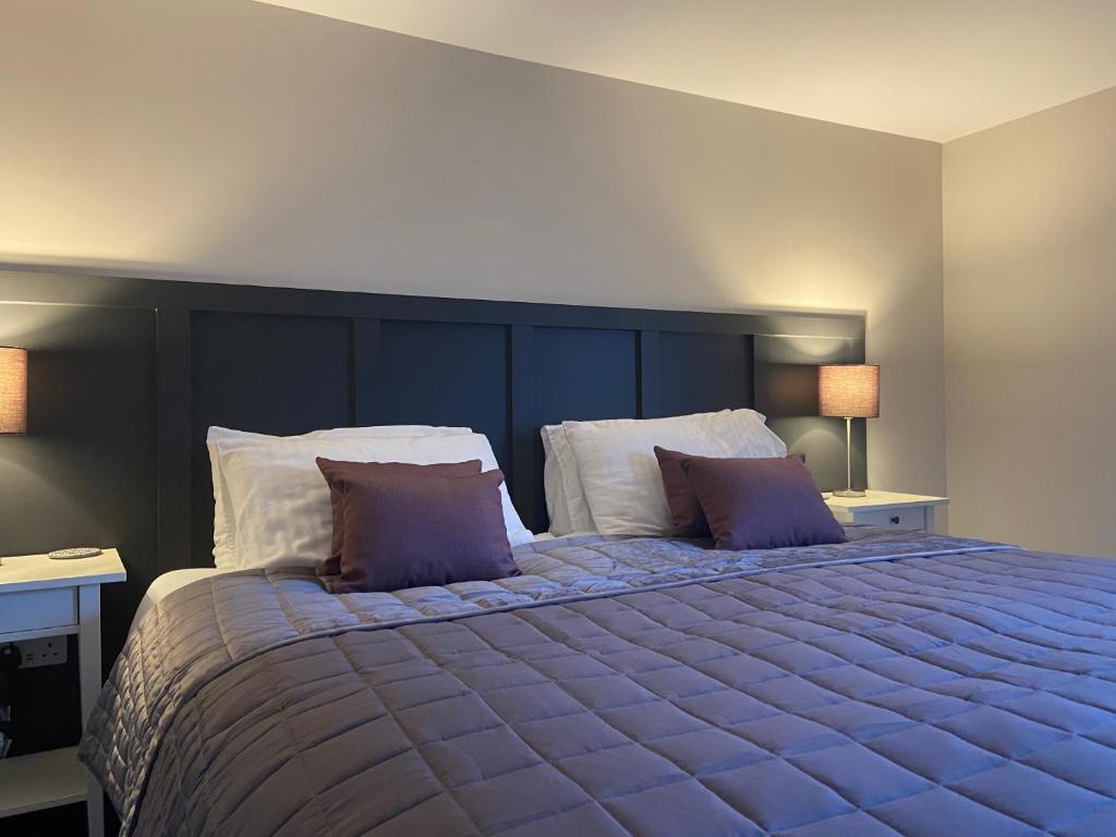 a bedroom with a large bed with two pillows at The Courtyard Apartment, Brampton Town Centre, Hadrians Wall - Sleeps 2 in Brampton