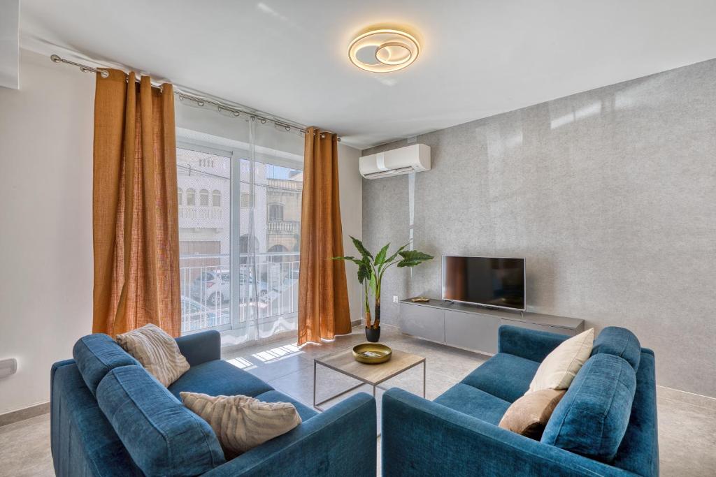 a living room with two blue couches and a tv at Spacious and refined 3 bedroom duplex KARP1-1 in San Ġwann