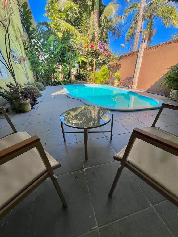 a patio with two chairs and a table and a pool at Pousada Castelinho in São Sebastião