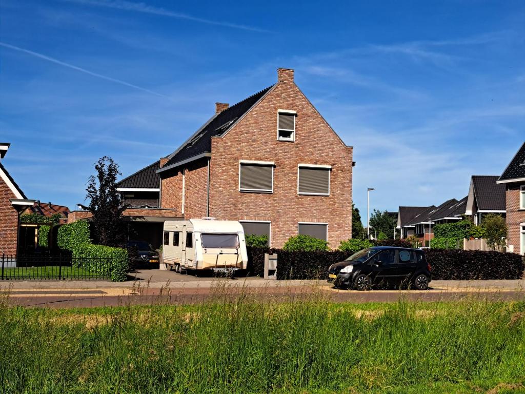 a van parked in front of a brick house at Villa shared Fieldsight Doornspijk - a shared villa no breakfast in Doornspijk
