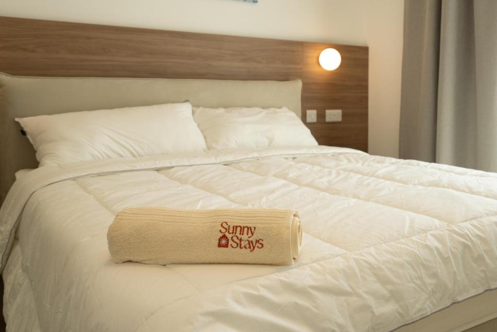 a white bed with a sign sitting on top of it at Vista Point Suites in Marsalforn