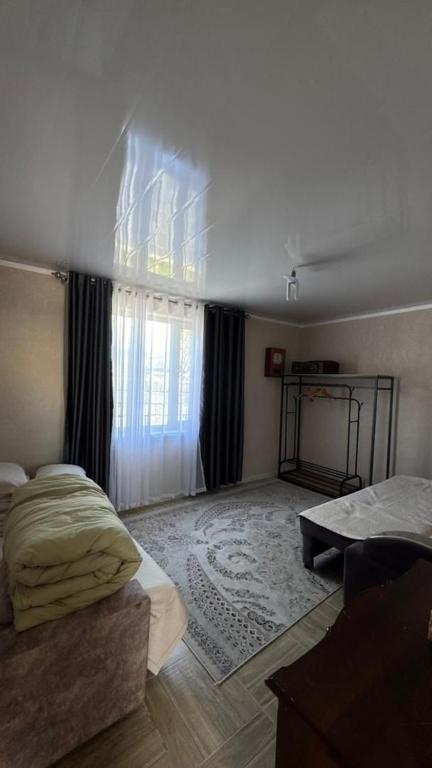 a living room with a bed and a window at Sarytam in Bosteri