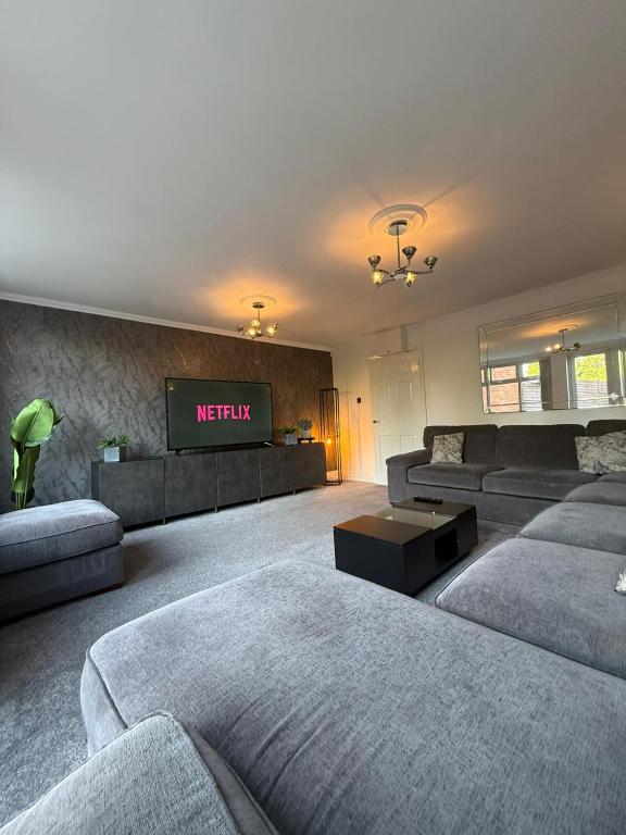 a large living room with couches and a tv at Emerald Manor - Free Parking - Free Wifi in Solihull
