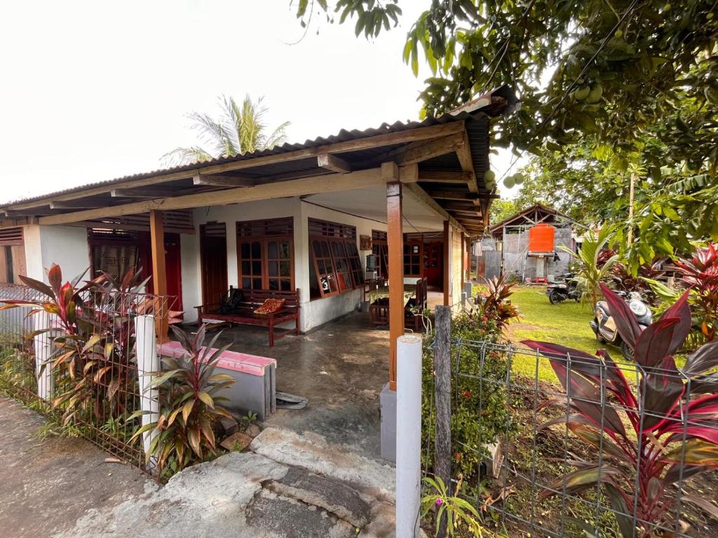 a small house with a porch and a fence at Bunaken Jhon Homestay in Manado