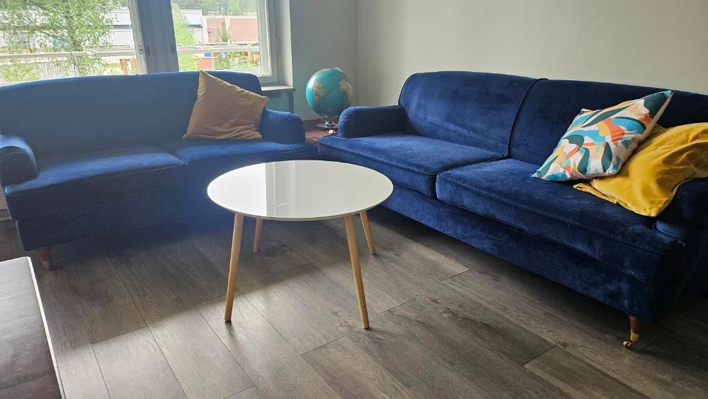 a living room with a blue couch and a table at Jämsän Kulma in Halli
