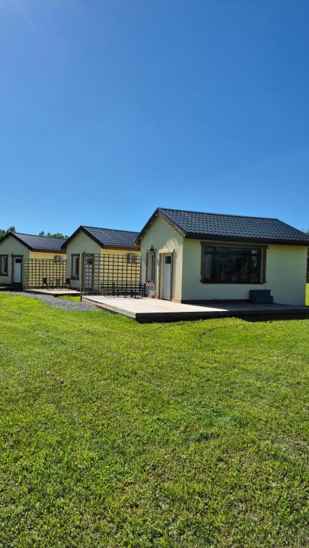 a row of houses with a green lawn in front at Ozolkungi in Turaida