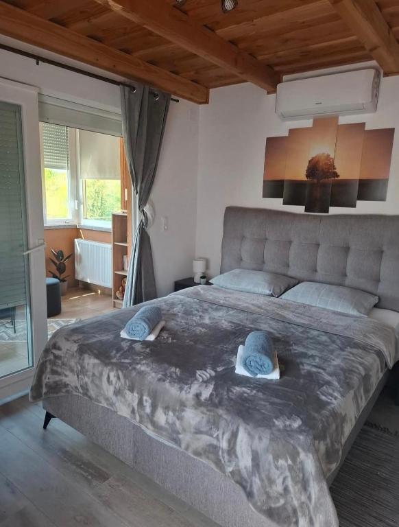 a bedroom with a large bed with two hats on it at Kuća za odmor Vila Valentina in Škriljevec