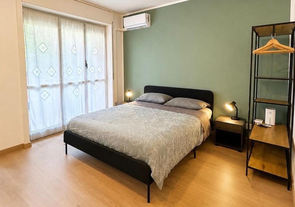 a bedroom with a bed and a large window at Nuara Urban Loft in Novara