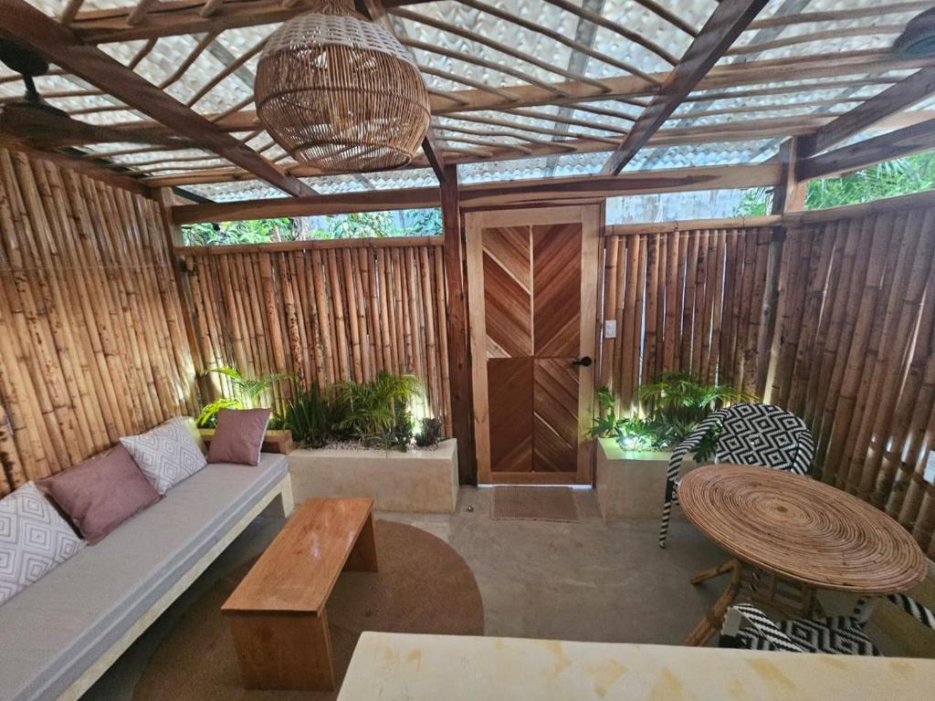 eine überdachte Veranda mit Sofa und Tisch in der Unterkunft Lula House in El Nido