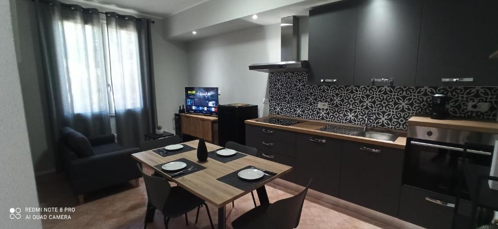a kitchen with a table with chairs and a kitchen with a stove at Neapolis casa vacanza in Terralba
