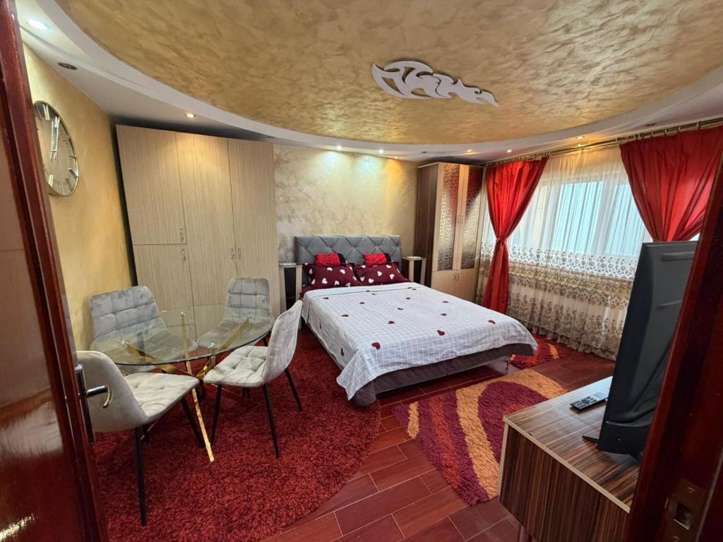 a bedroom with a bed and a table and a television at Apartament MARY in Constanţa