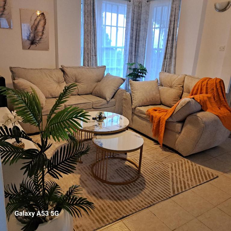 a living room with a couch and a table at RyNa Homes in Meru