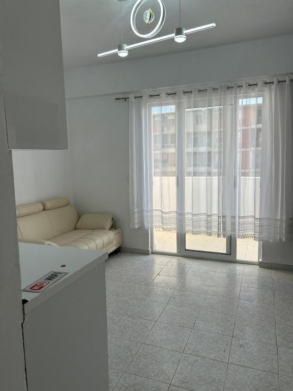 a living room with a couch and a large window at SeaView 7 Floor -No Elevater in Durrës