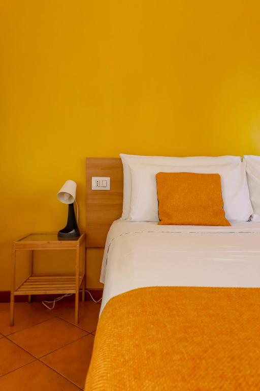 a bedroom with a bed and a yellow wall at B&B Le Palme in Grottammare