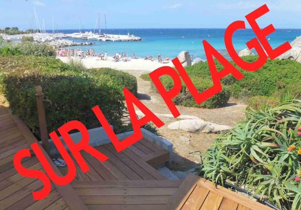 a sign that says surf resort with a beach in the background at Sur la plage in Lumio