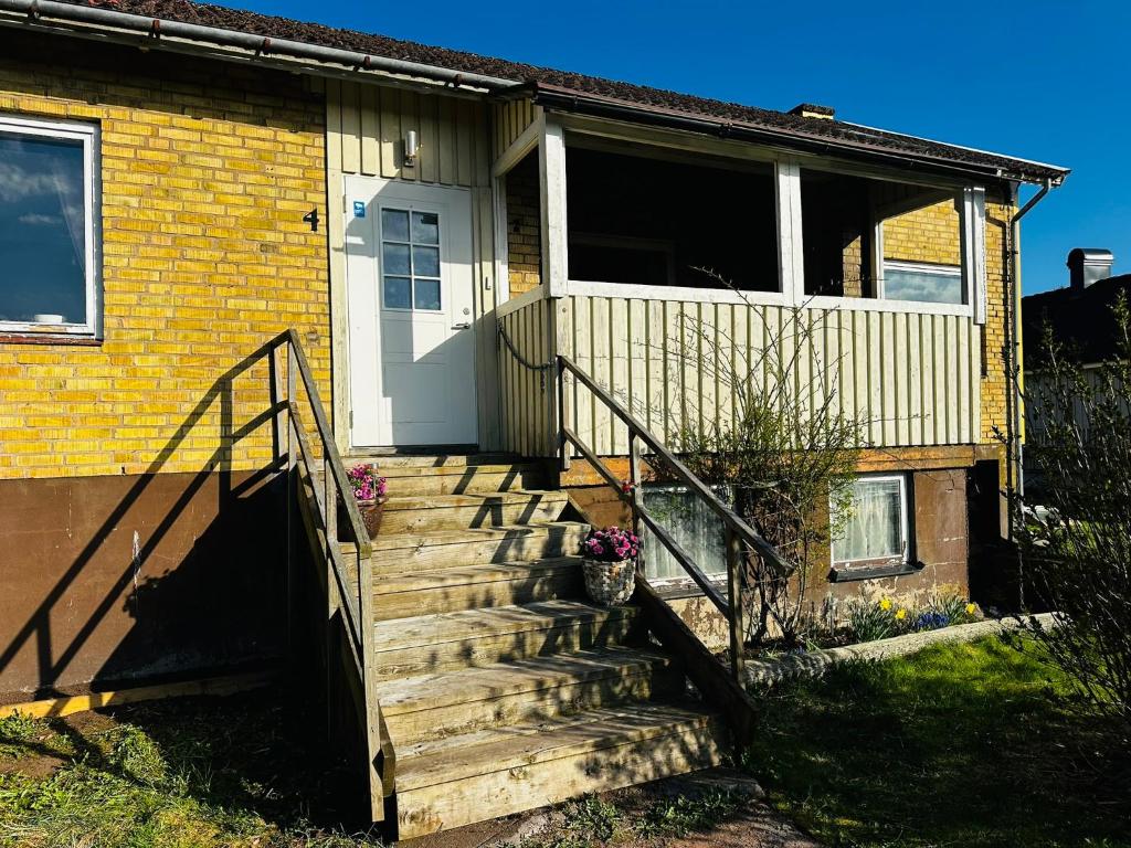 a wooden staircase leading to a house with a door at Charmigt hus uthyres in Holsljunga
