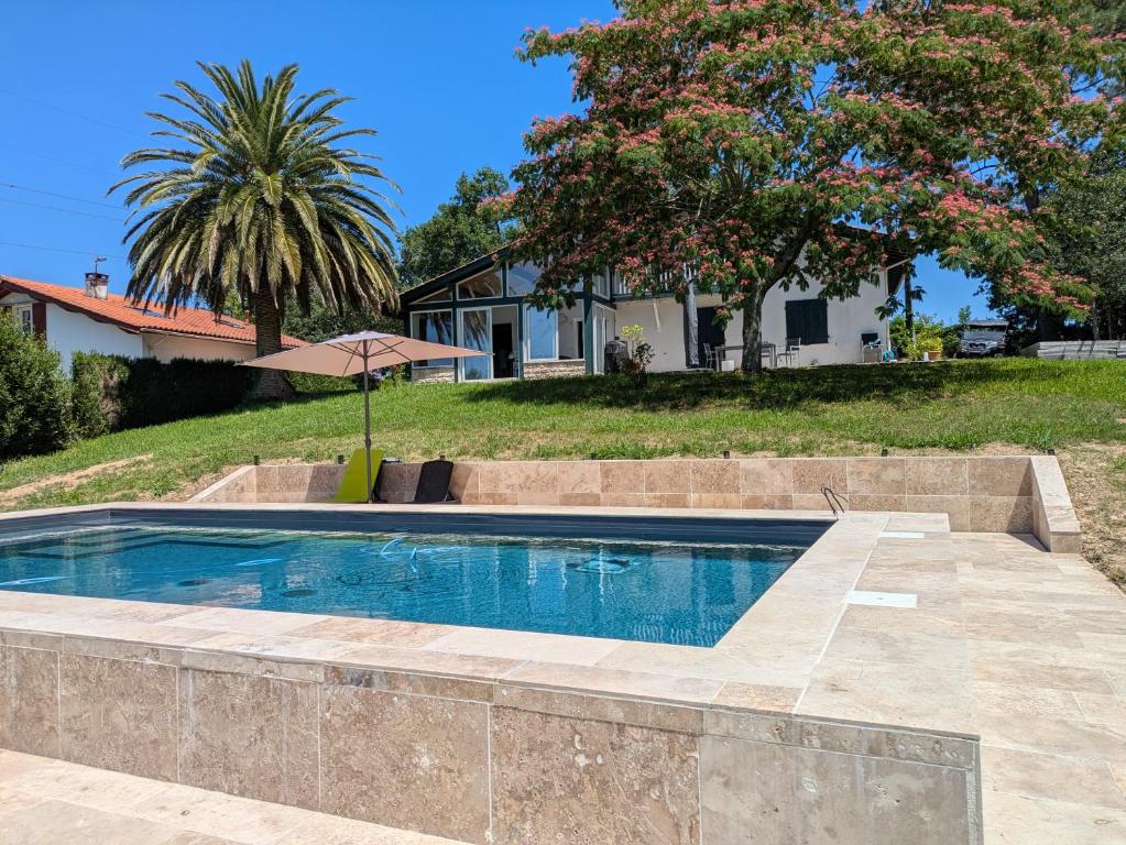 a swimming pool in front of a house at maison et table d'hôtes Xori Kanta in Ascain