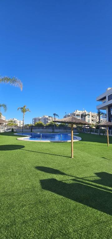 a grassy field with a bridge in the background at Private Garden Apartment - Villamartin, Orihuela Costa in Villamartin