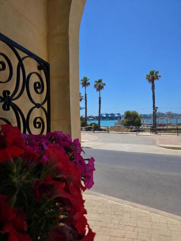 a building with flowers on the side of a street at Arzella Beachfront Guesthouse in Birżebbuġa
