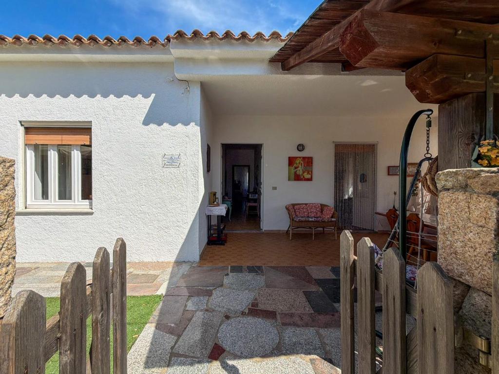 a white house with a wooden fence in front of it at Budoni Casa Vacanze - MAR DEI CORALLI in Budoni