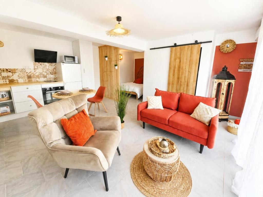 a living room with two chairs and a red couch at Cocon d'Amour & Spa in Le Thoronet