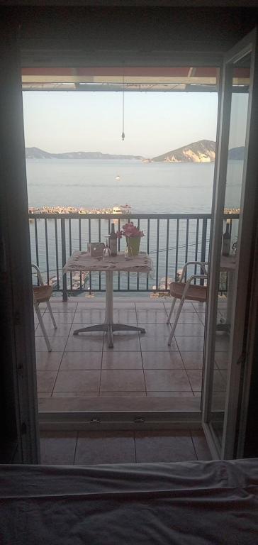 a balcony with a table and a view of the ocean at attic sea view studio in karmiris studios in Zakynthos