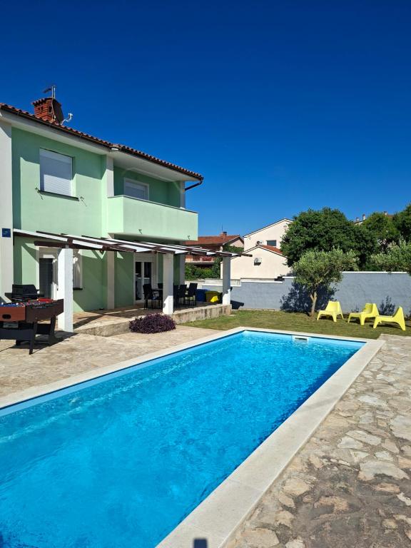 a villa with a swimming pool and a house at vila lokvanj in Ližnjan