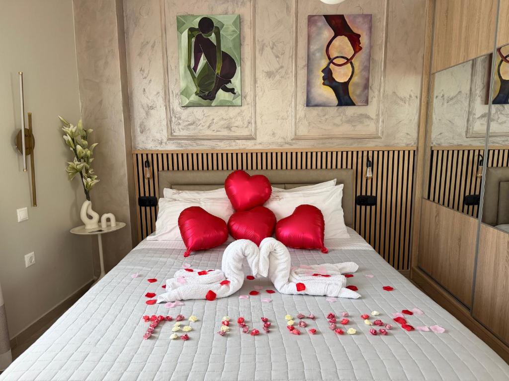 a bed with red pillows and flowers on it at Psimithefto Luxury Apartments in Thessaloniki