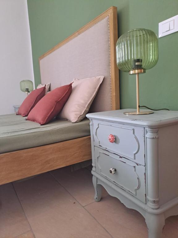 a bed with pillows and a lamp on a night stand at Chioma verde in Chioma