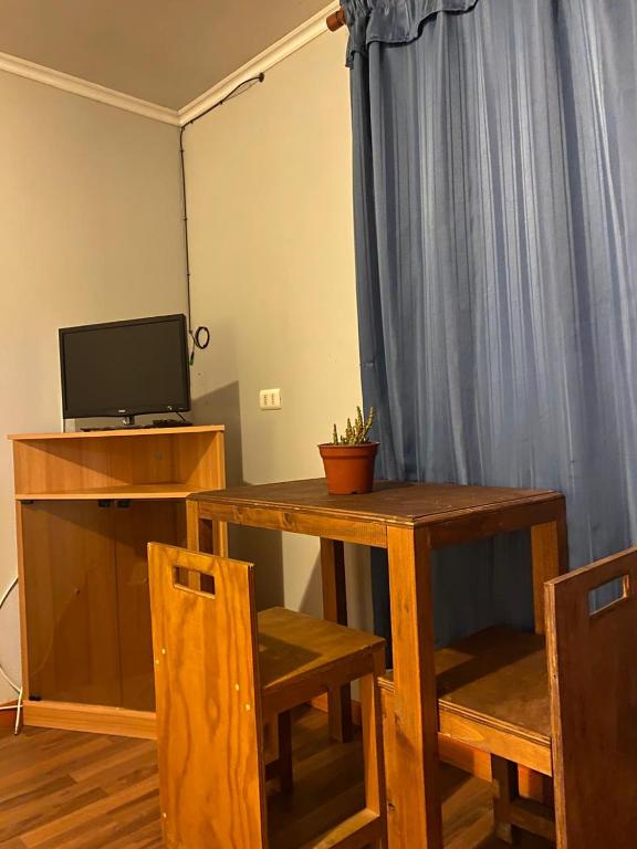 a room with a table and a television and a table and chairs at Hostal El Boldal Marchigüe in Marchihue