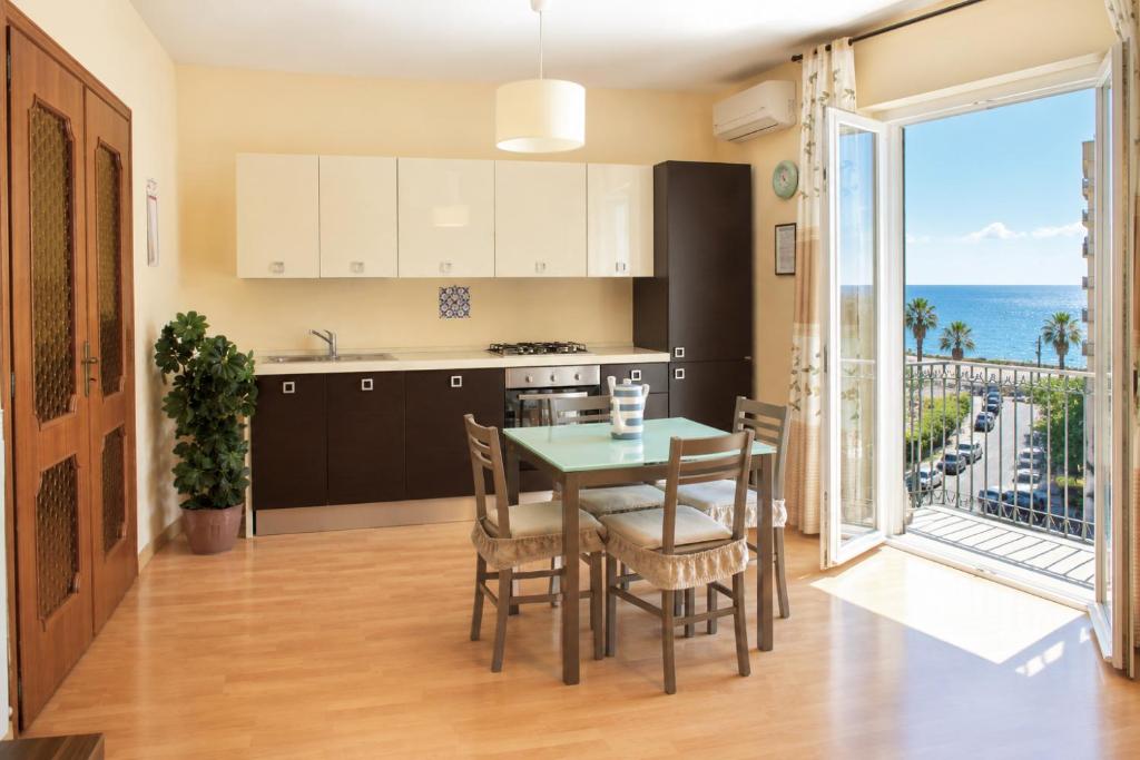 a kitchen and dining room with a table and a view of the ocean at Tari Home Crotone in Crotone
