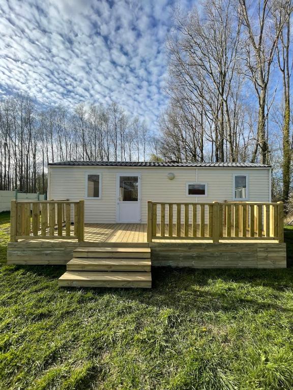a home with a deck and a house at Chloe Bungalow in Bourbourg